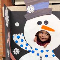 Alumni's child posing in snowman cut out